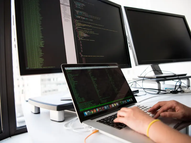 Desarrolladora programando frente a varios monitores